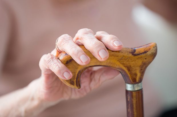 elderly woman holding her walking stick