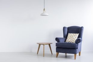 Blue armchair and wooden side table on white background